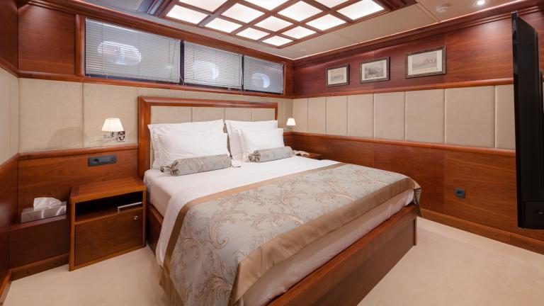 Ein schlichtes Zimmer mit bequemen Doppelbett und Einbauschränken aus edlem Holz.